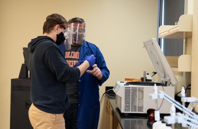 student working with professor in lab